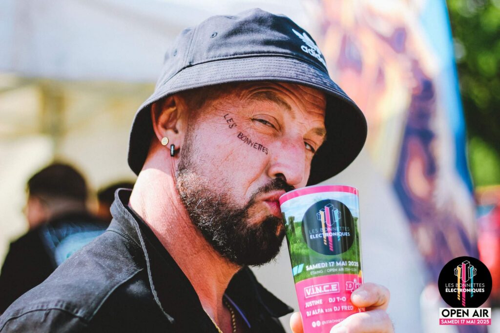Festivalier profitant de l'ambiance avec un gobelet officiel du festival à Étaing.