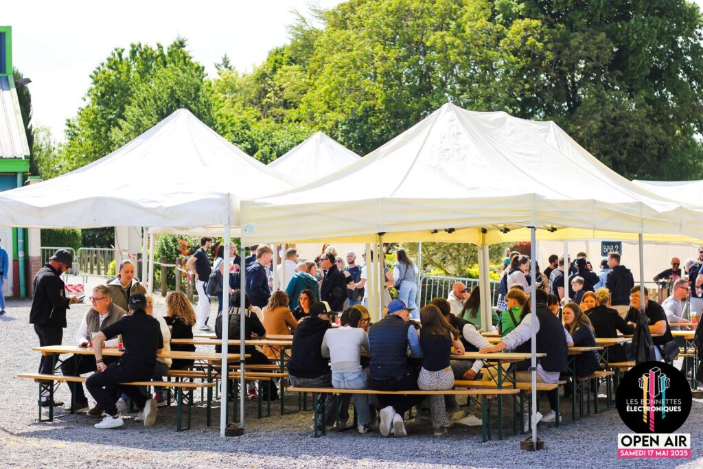 Espace restauration et détente sous les tentes blanches pour les festivaliers à Étaing lors de l'édition 2025.