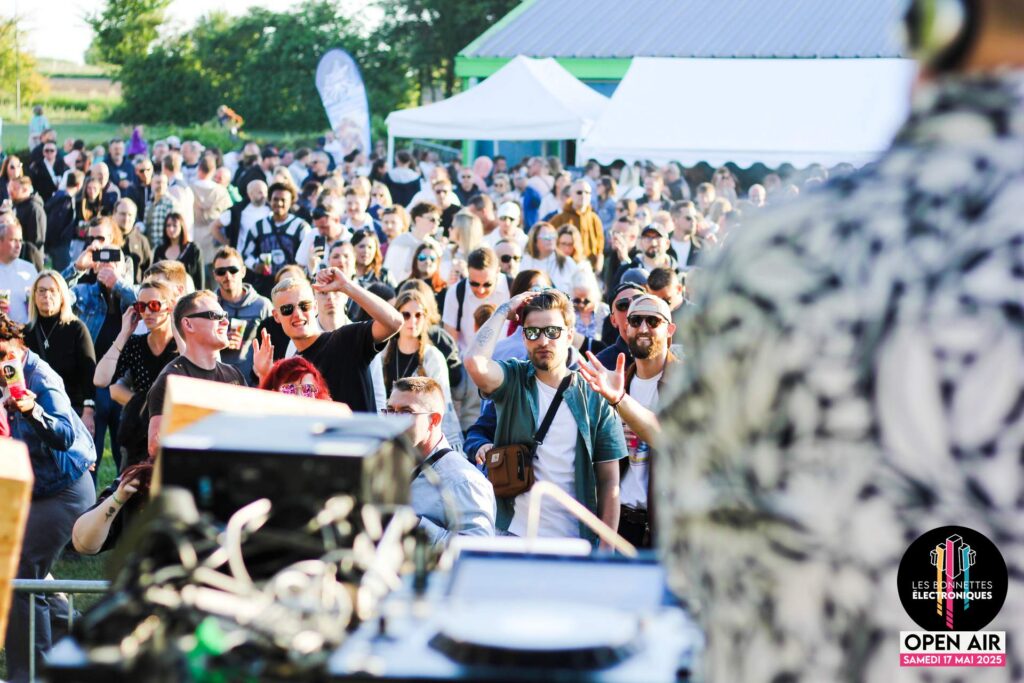 Vue de la foule de festivaliers dansant lors de l'Open Air des Bonnettes Électroniques à Étaing.