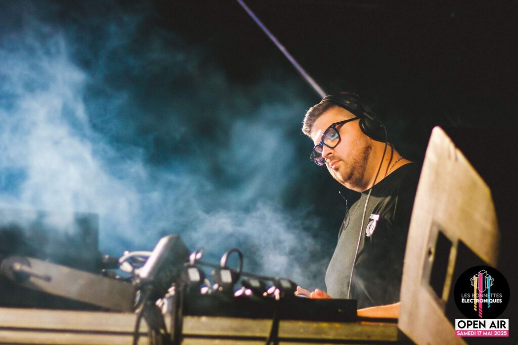 Performance de DJ T-O aux platines, entouré d'effets de fumée sur la scène des Bonnettes Électroniques 2025.