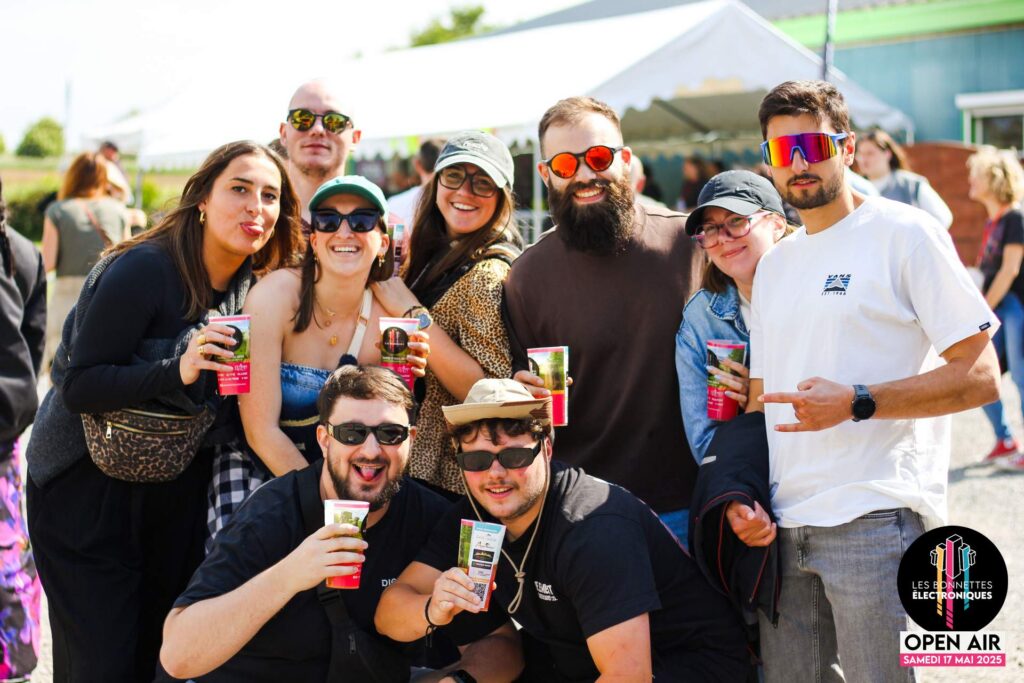 Groupe de festivaliers souriants profitant du soleil et de l'ambiance à Étaing lors de l'édition 2025.