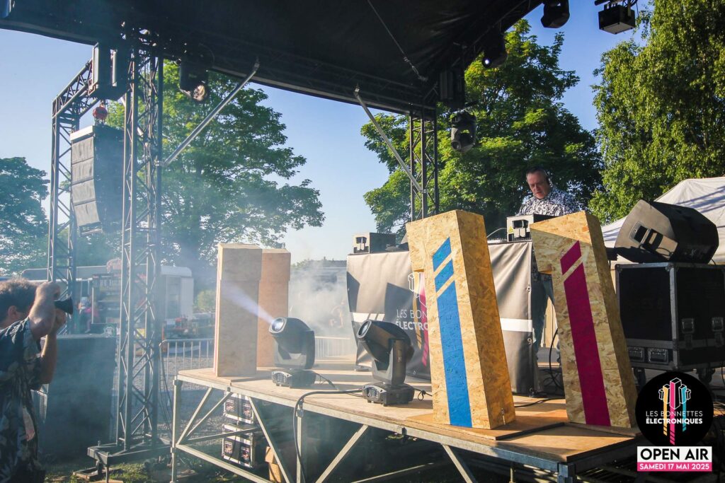 L'artiste DJ HS aux platines sur la scène décorée de l'édition 2025 des Bonnettes Électroniques.